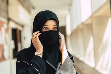 Muslim niqab woman close hide her face. Arab saudi girl closeup close face with black chador.