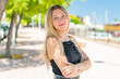 © luismolinero - Young blonde woman at outdoors with arms crossed and looking forward
