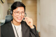 close up asian man call center agent wear headset device and smiling working in operation room with service-mind at desktop table for telemarketing and help desk background concept