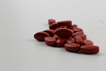 Closeup shot of red vitamins on a white background.