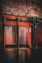 Vertical Shot Of Old Red Rusty Shipping Container Door With Technical Characteristics Text