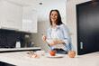 © SHOTPRIME STUDIO - Happy woman preparing healthy meal in her kitchen, holding a bowl of delicious food in hands