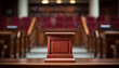 The image shows an empty wooden podium in a courtroom with empty red velvet seats.