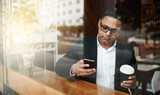 Fototapeta Panele - Coffee shop, business and man with smartphone, typing and texting contact for schedule and deadline. Person, employee and entrepreneur with morning tea and espresso with cellphone to message client