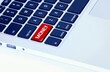Closeup of a laptop keyboard with a red money button