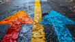 Colorful arrows painted on the asphalt in the rain. Yellow, red and blue arrows.