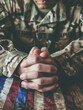 A close-up of a military service member's calloused and weathered hands, clasped in a moment of quiet reflection - a powerful symbol of the sacrifices made in service to the nation.