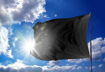 Wall Mural - Conceptual image of waving blank black flag over sunny blue sky