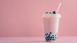 A pink boba tea with strawberries and ice cubes, surrounded by splashes of water on a white background, in the style of stock photography. A glass cup full of strawberry milk bubble tea.