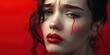 Portrait of a young sad crying woman with smeared red lipstick and flowing mascara on colored background with copy space.