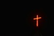 red lamp bulb light in cross on rooftop of Christian church in night sky background