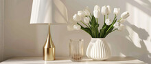 White Tulips Flowers Plant In A Vase And Striped Glasses On A Wooden Table Next To A Gold Lamp With A White Lampshade Created With Generative AI Technology