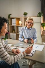 Wall Mural - Two mature woman have coffee break at office