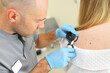 dermatologist examines neoplasms on the patient's skin using a special dermatoscope device. Prevention of melanoma.