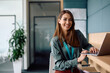 © Drazen - Portrait of happy businesswoman working on laptop  computer in office and looking at camera.