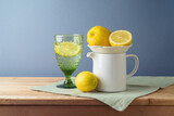 Fototapeta  - Summer composition with lemons and white jug on kitchen wooden table