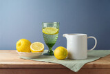 Fototapeta Nowy Jork - Summer composition with lemons and white jug on kitchen wooden table