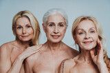 Fototapeta Londyn - Image of three beautiful senior women posing on a beauty photo session. Middle aged women in lingerie holding hands close to face. Concept about body positivity, self esteem, and body acceptance.