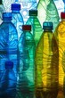 A variety of empty plastic bottles, showcasing differing colours and transparencies, are aligned closely together, with light shining through them, creating a vibrant and textured visual effect