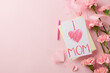 Mother's day affection: top view of handmade card and carnations on a soft pink background