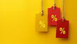 hanging sales tags on yellow solid background with copy space