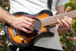Guitarist playing an electric guitar outdoors close up