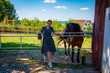 Woman with horse in stable at countryside ranch. Girl horse rider in summer outdoor. Equestrian and horseback riding. Horse stallion equine with Hispanic woman girl. Countryside ranch. Dude ranch