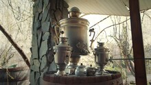 Vintage Samovar Stands On A Table In An Ancient Village Hut, A Primitive Interior
