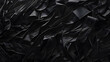 Black crumpled paper texture. Close-up shot. Abstract and versatile background for design and print, suitable for banner or wallpaper
