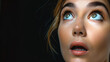 © Nataliia_Trushchenko - A woman with green eyes and blonde hair is looking up at the camera. She has a surprised expression on her face. Woman's face which looks sideways in happily amazement. eyes directed to the right.