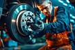 Repairman in uniform working with brake disc in auto repair shop. Auto service industry.