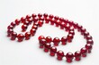 A simple red bead necklace on a clean white background. Perfect for jewelry or fashion concepts