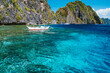 Banca boat moored und crystal clear ocean water near Matinloc island, highlights of hopping trip Tour C. Most beautiful place at Marine National Park, Palawan