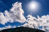 Fototapeta Kwiaty - Clouds and sun over mountain, hill