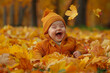 © hassan - Adorable baby sitting in a pile of autumn leaves, laughing with joy.