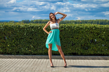 Wall Mural - Young beautiful brunette woman in a turquoise dress