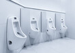 Men's room with white porcelain urinals in line