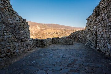 Wall Mural - Historic stone walls overlooking sunlit forested hills.