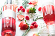 © Cavan Images - Two rose bottle laying on white backdrop with strawberries and r
