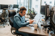 © Cavan Images - Young man working on laptop in office