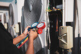 Fototapeta Mapy - Heat and Air Conditioning, HVAC system service technician using measuring manifold gauge checking refrigerant and filling industrial air conditioner after duct cleaning maintenance outdoor compressor.