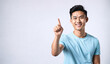 a smiling young man in a blue shirt is pointing upwards, asian male, pointing index finger, isolated white background, website banner, copy space, background
