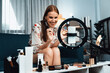 © InfiniteFlow - Woman influencer shoot live streaming vlog video review makeup utmost social media or blog. Happy young girl with cosmetics studio lighting for marketing recording session broadcasting online.