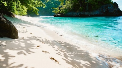 Wall Mural - Footprints in the soft, white sand leading to a secluded cove, where the water sparkles with a thousand shades of blue.