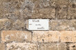 Cartello con indicazioni su vecchio muro