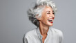 a woman with grey hair laughing with a big smile on her face