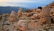 Ancient sculptures on Mount Nemrut at sunset with a cloudy sky in the background in Turkey