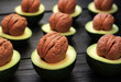 The concept of food combination. Fresh avocado fruits are cut in half and walnuts are inserted in place of the seeds. Healthy, wholesome food rich in vitamins, minerals, and plant-based unsaturated fa