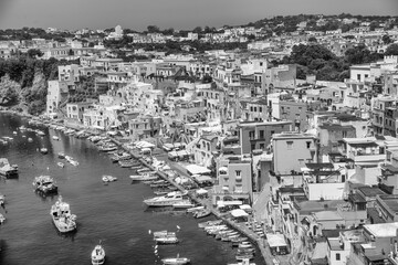 Wall Mural - Aerial grayscale view of Procida Island with ships and beautiful buildings along the coastline