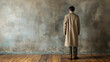 © Nemanja - Rearview of man wearing a beige coat, standing in a room with an empty wall and hardwood parquet floor. Free empty blank copy space for text